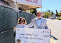 Maxine Littlejohn, business committee member for Santa Ynez Band of Chumash Indians, and Mark Herrier, executive director for the Lompoc Theatre Project, outside the Lompoc Theatre. (Courtesy photo)