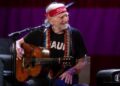 Willie Nelson grins at harmonica player Mickey Raphael on their Outlaw Music Festival tour stop at Raleigh, N.C.’s Coastal Credit Union Music Park, Saturday night, Sept. 8, 2023.
