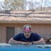 a person resting on the edge of a swimming pool with a card on their forehead