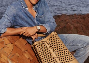 a person posing with a stylish handbag near the water