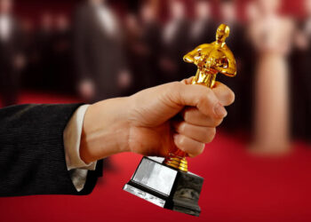 a hand holding an Oscar statue