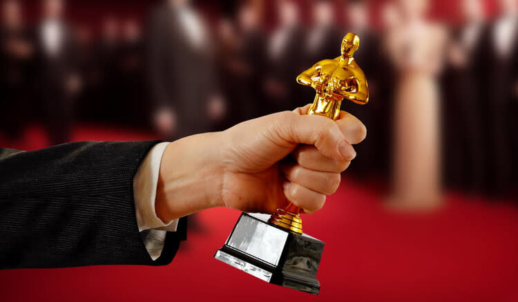 a hand holding an Oscar statue