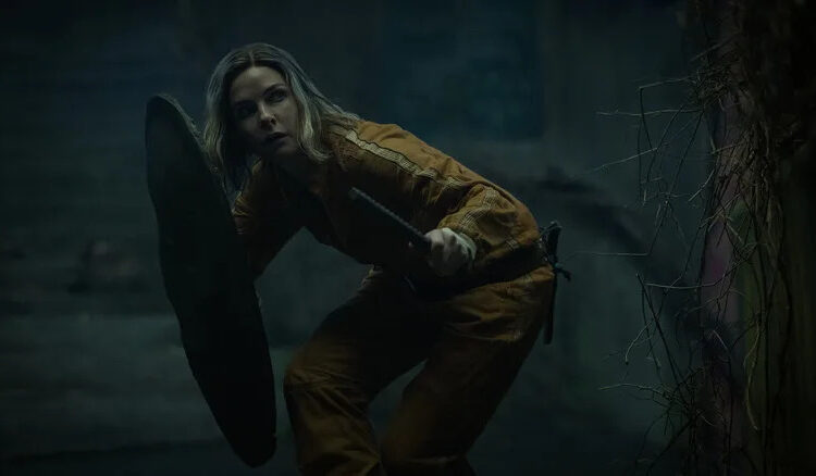 Juliette protecting herself with a shield as she crouches stealthily in Silo