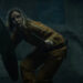 Juliette protecting herself with a shield as she crouches stealthily in Silo