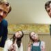 Two men and two girls lean in toward the camera in The Nice Guys.