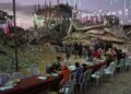Palestinians sit at a long table amid the rubble of destroyed buildings as they gather for iftar, the fast-breaking meal, during the Muslim holy month of Ramadan in Khan Younis, Gaza Strip, Thursday, Feb. 19, 2026. (AP Photo/Abdel Kareem Hana)