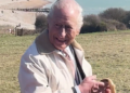 King Charles smiles as he looks at the Seven Sistiers