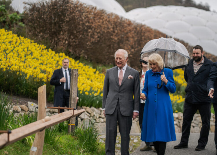King Charles and Queen Camilla walk through the Eden Project, passing a bank of yellow flowers