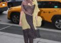 Fashionable individual posing on a city street.