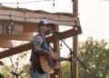 Christopher Seymore, who calls himself a “hillbilly poet,” sings a tune from a newly built stage at Long Step Ranch in Del Valle. The property, about 20 minutes west of Bastrop, is actively being built to increase amenities for guests. (Joel Valley/Community Impact)