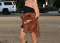 Person walking on a sidewalk wearing a casual outfit.