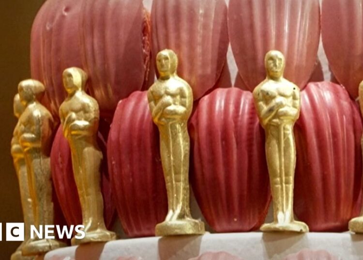 A cake decorated with edible gold Oscar statuettes