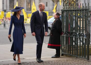 William and Kate arrive for the Commonwealth Day service as protestors demonstrate in the background