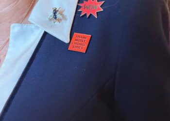 Queen Camilla wore two badges: WOW and 'Shame must change sides'