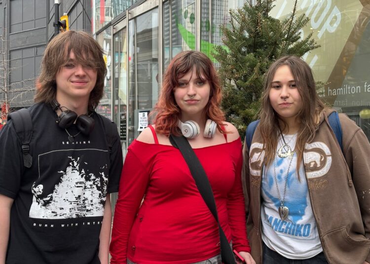 three teens smile at the camera