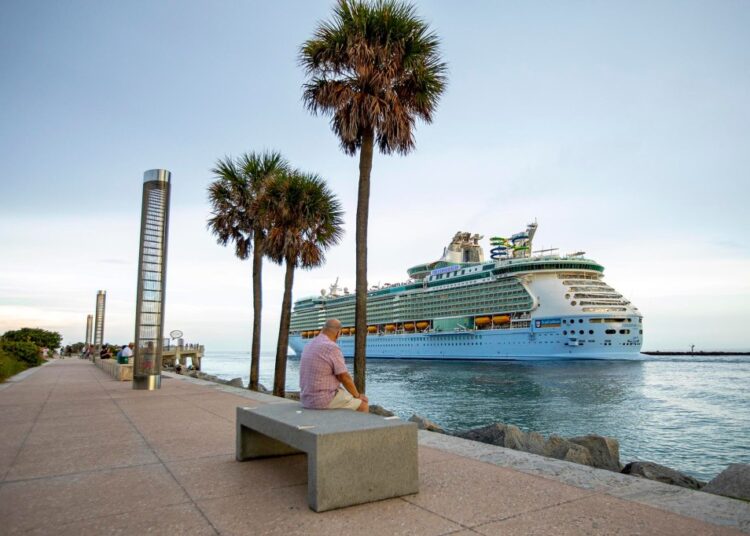 Man watching the Royal Caribbean International's Freedom of the Seas cruise ship depart from PortMiami.