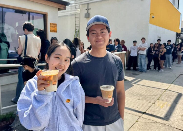 Two people holding Skims x Community Goods latte cups.