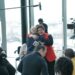 Nicola Sturgeon stood up and hugging someone in a room filled with people.