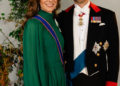 The Prince and Princess of Wales stand in front of a plant for a formal portrait