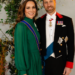 The Prince and Princess of Wales stand in front of a plant for a formal portrait
