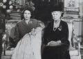 Queen Elizabeth II holds King Charles III with Queen Mary at her side and King George VI standing behind them