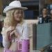 A woman in a white cowboy hat smiles.