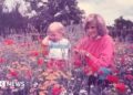 Prince William aged 2 stands in a field of flowers with his mother the late Princess of Wales
