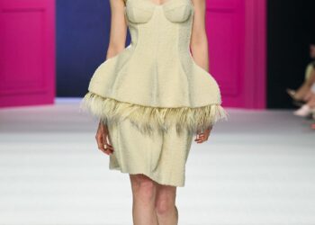 Model walking the runway in a unique fashion design.