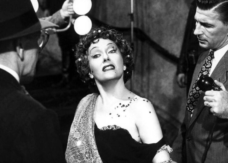 A glamorous older woman poses dramatically in "Sunset Boulevard"