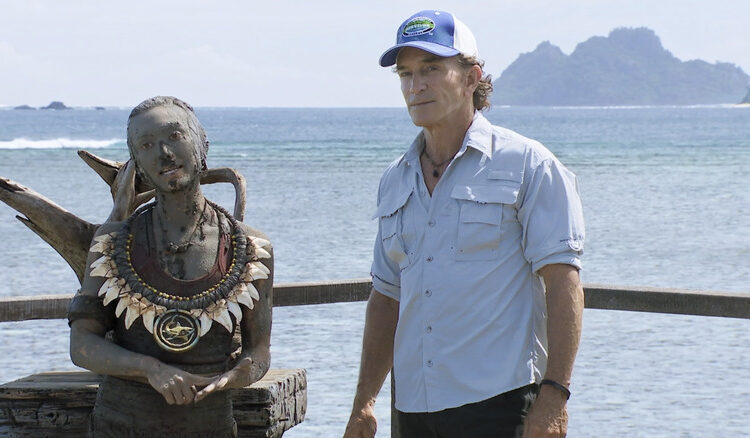 Jeff Probst standing in front of ocean next to woman, Savannah Louie, who is covered in mud in Survivor