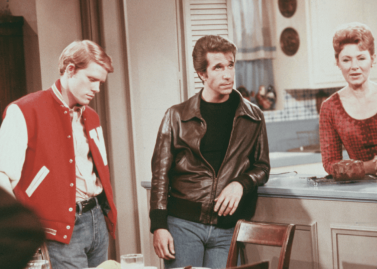 American actors Henry Winkler, as Arthur 'Fonzie' Fonzarelli, Ron Howard as Richie Cunningham, and Marion Ross as Marion Cunningham, in a scene from the television sitcom 'Happy Days', circa 1975. -