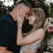 Couple sharing a kiss in a floral garden setting.