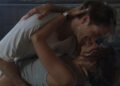 A couple does a dip, embracing and smiling.