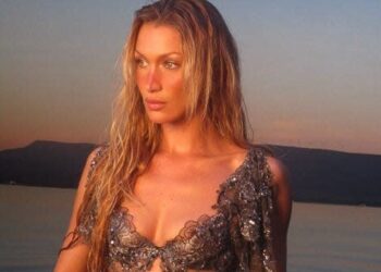 Person in the water at sunset wearing a decorated outfit.