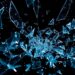 An extreme close-up of shattered glass and glittering shards in dramatic high-contrast studio lighting, conceptually representing the digital attacks and retaliation Lively faced after speaking up.