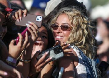 Sydney Sweeney takes photos with the front row fans just before BigXthePlug performed on the Mustang Stage during the Stagecoach Festival in Indio, Calif., April 24, 2026.