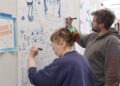 Merry Winch, left, of Port Angeles and Baillieu Lewis add to the doodle wall at the All In Arts Studio, 129 W. First St., Port Angeles.