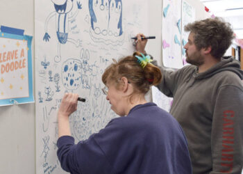 Merry Winch, left, of Port Angeles and Baillieu Lewis add to the doodle wall at the All In Arts Studio, 129 W. First St., Port Angeles.