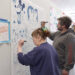 Merry Winch, left, of Port Angeles and Baillieu Lewis add to the doodle wall at the All In Arts Studio, 129 W. First St., Port Angeles.