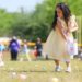 A child puts an easter egg into a basket.