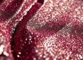 An extreme close-up of shimmering, glittering sequins reflecting dramatic studio lighting, conceptually representing the glamour and exclusivity of the Guess Compound party during Coachella.