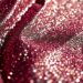 An extreme close-up of shimmering, glittering sequins reflecting dramatic studio lighting, conceptually representing the glamour and exclusivity of the Guess Compound party during Coachella.