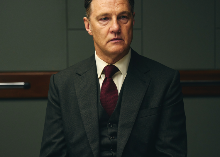 man sitting at a table dressed in a suit