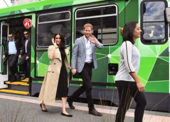 Britain's Prince Harry and Meghan, Duchess of Sussex wave to the well-wishers after taking a ride on a tram in Melbourne.