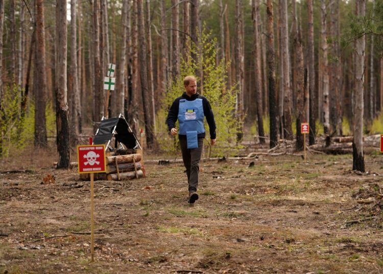Britain's Prince Harry, the Duke of Sussex, walks in a forest as he visits members of the HALO Trust (Hazardous Area Life-support Organization), a non-commercial charity organisation for demining