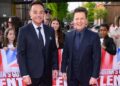 Ant & Dec stood next to each other wearing suits, smiling ahead on a red carpet.
