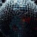 An extreme close-up of shattered, glittering glass fragments in high-contrast studio lighting, conceptually representing the competitive and volatile nature of the music business.
