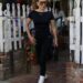 A person walking out of a café dressed in black athletic wear.