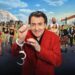 Six pairs stood either side of a super imposed Jonathan Ross, who is wearing a red suit with a set of handcuffs hanging from his hand.