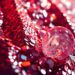 An extreme close-up photograph of sparkling sequins and shattered glass, capturing the luxurious textures and high-energy glamour of Coachella festival fashion.